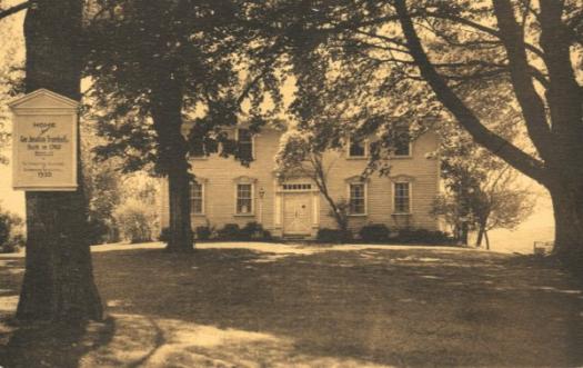 old photo of a building that is obscured by trees