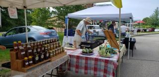Vendors at the Lebanon, Connecticut Farmers' Market selling honey and fresh cooked breakfast sandwiches with local ingredients